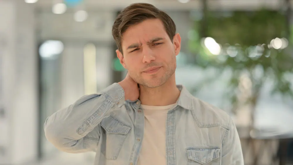 a man suffering from neck pain from poor posture