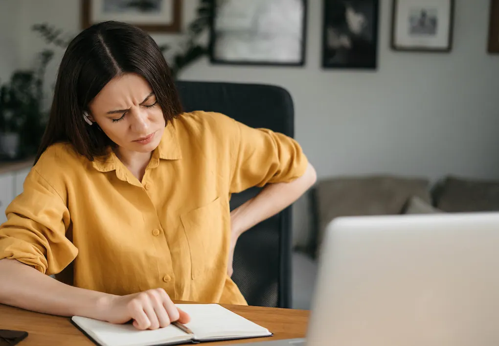 a woman having a back pain from poor posture