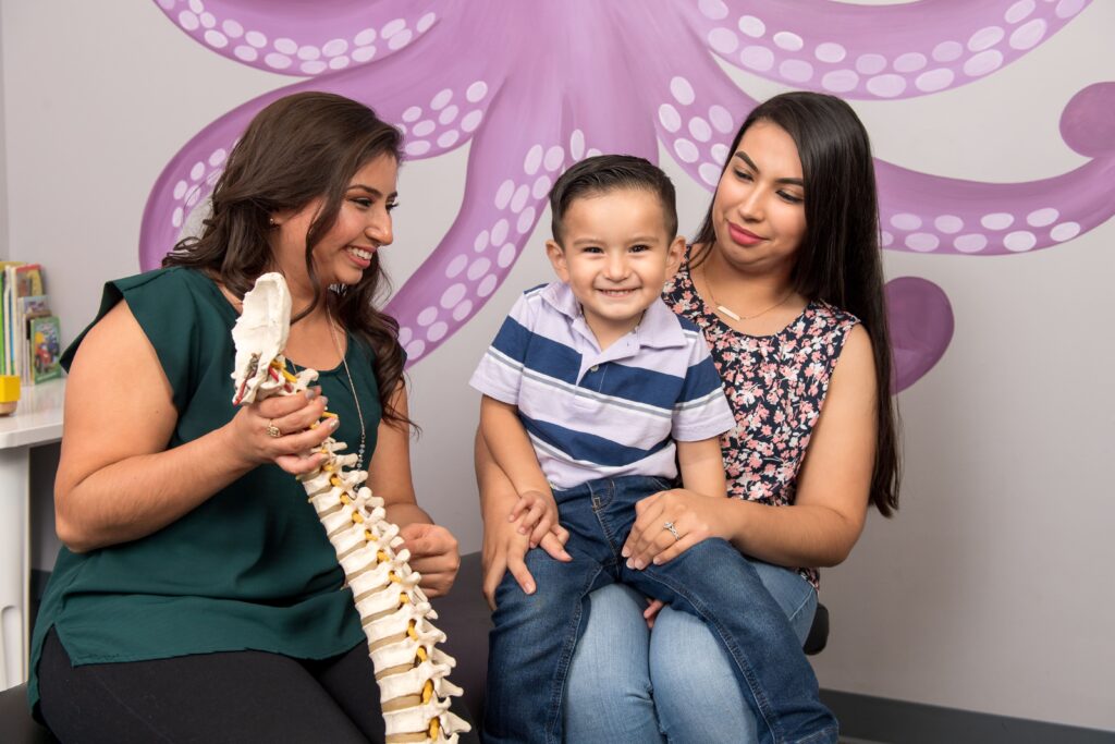 Dr Martha Manzanarez demo the spine model to mother and son