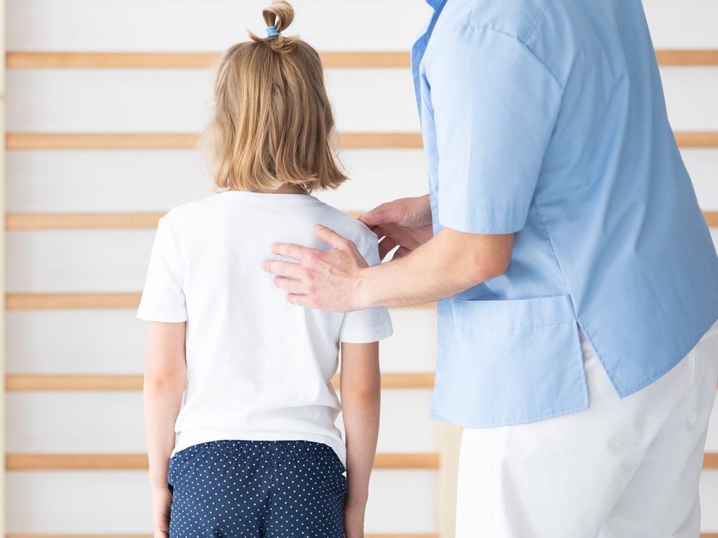 a chiropractor check the girl's back due to scolioisis